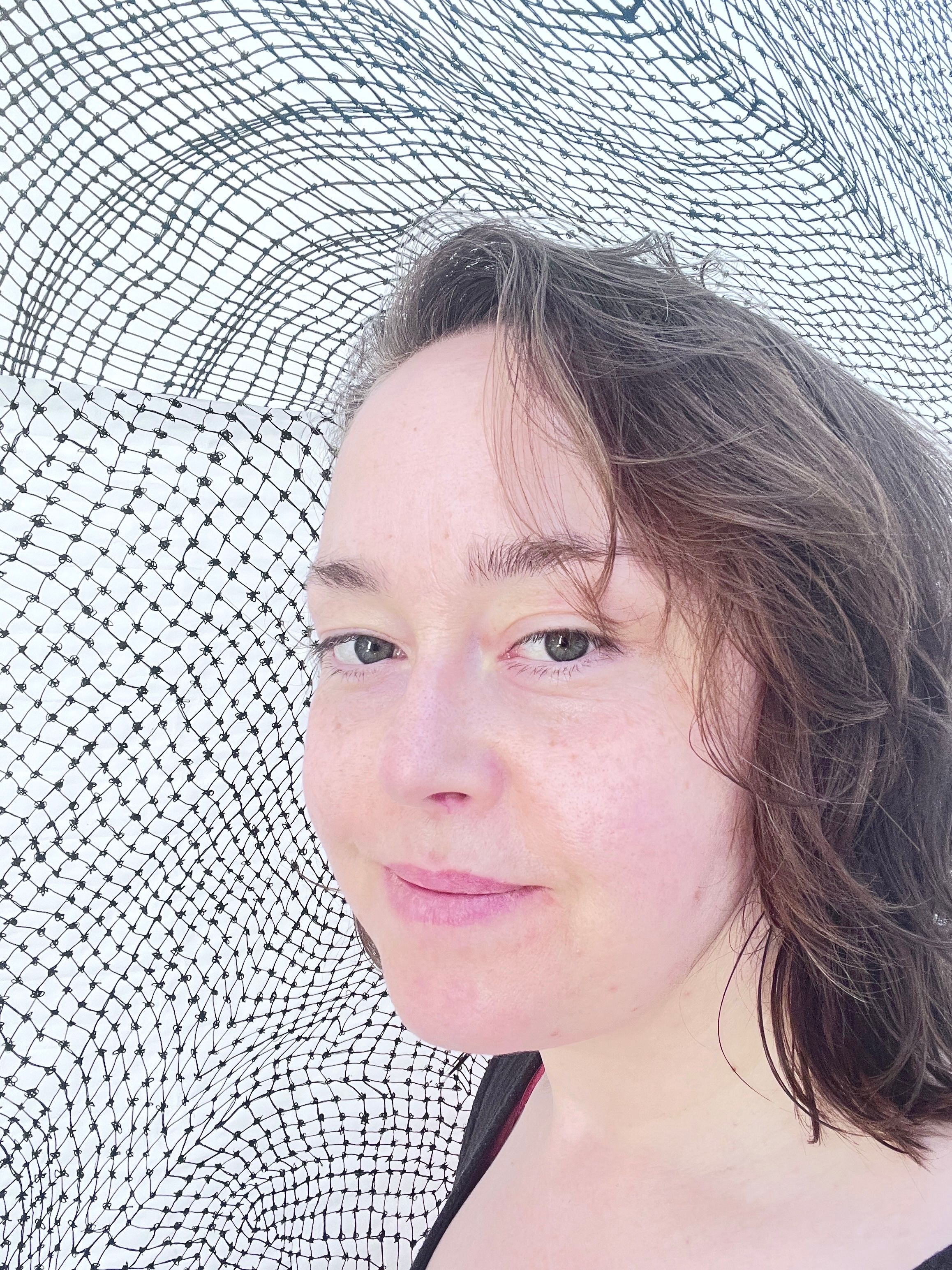 Photo of Emily Charlotte Duchscherer Kirk, the background is her What a MESH! or meshy, net drawings