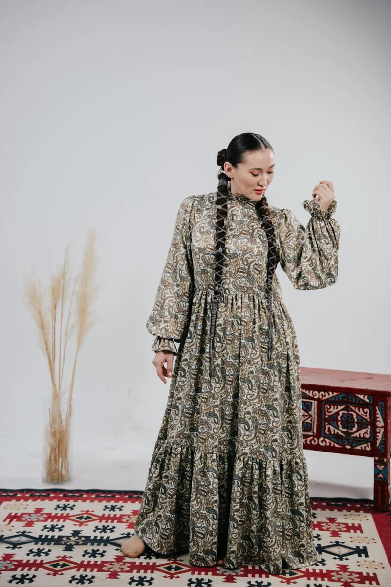 Banu Gaidar in a long patterned dress, in profile