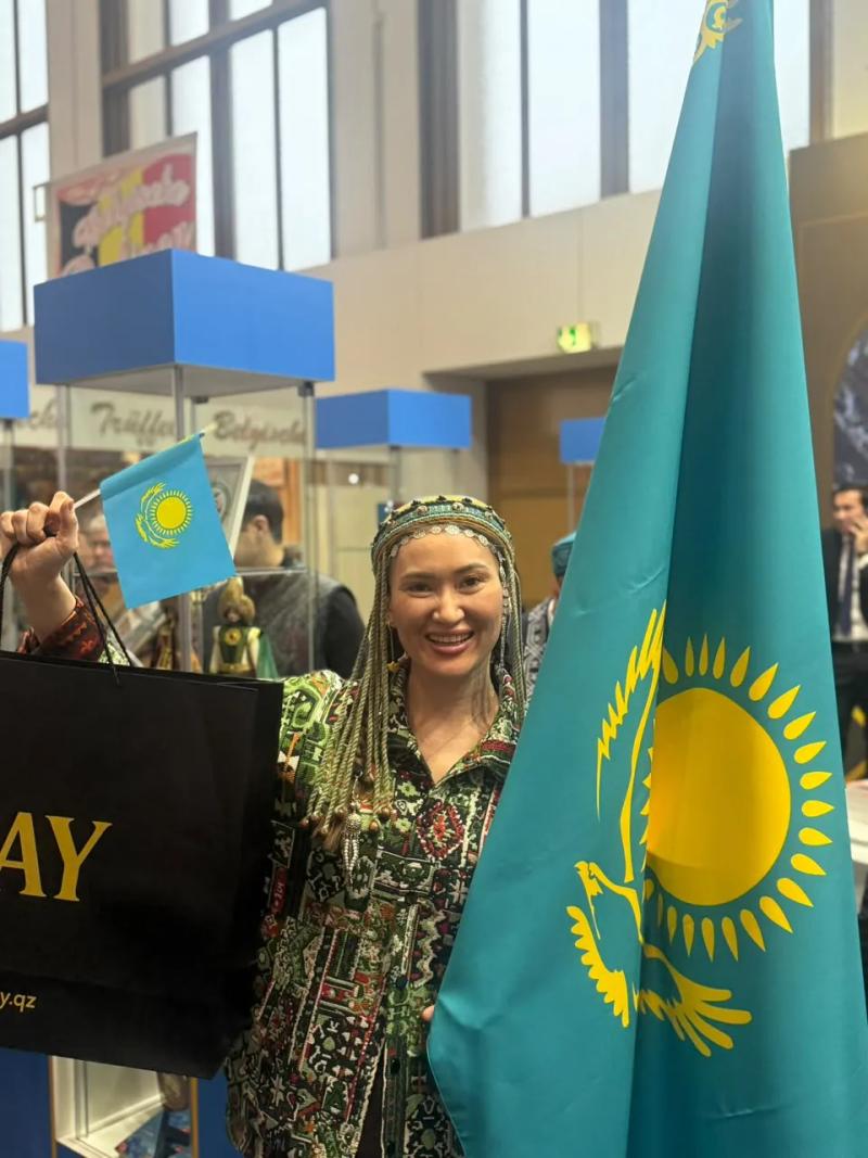 Banu Gaidar with the flag of Kazakhstan and a BAY bag