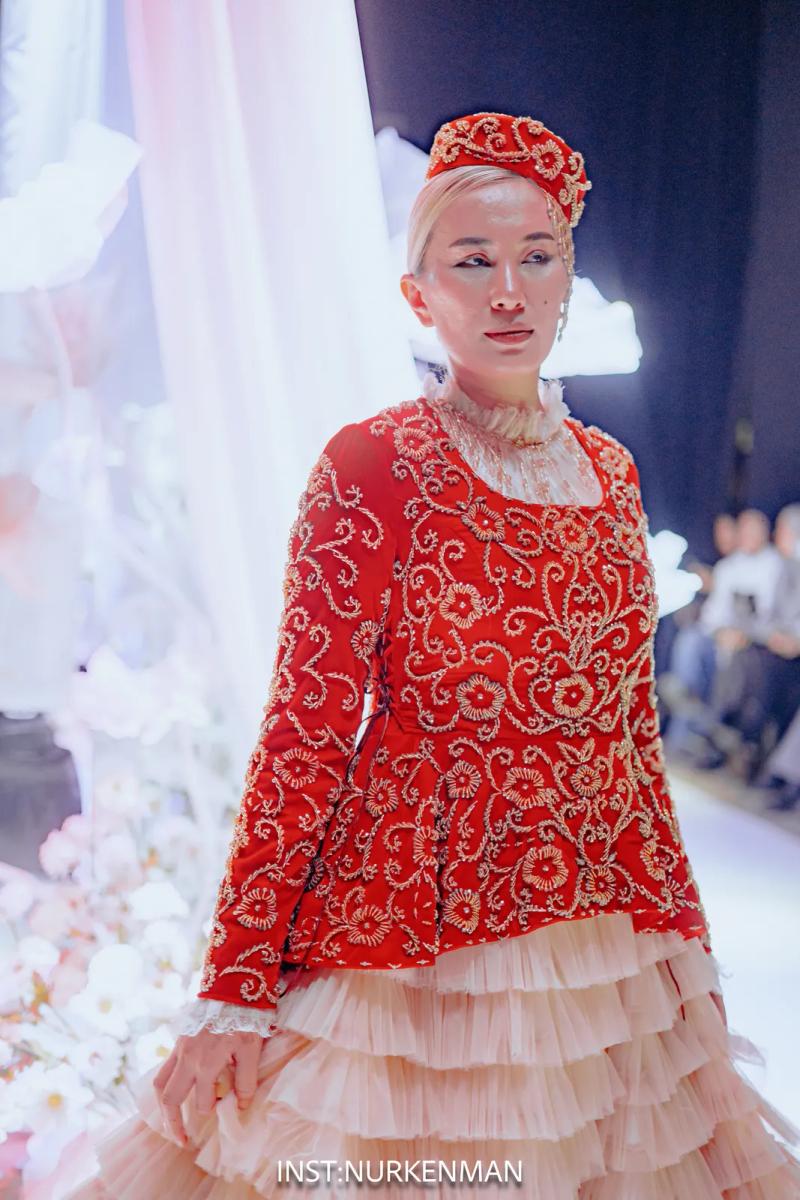 Model in a red embroidered jacket and a tiered skirt