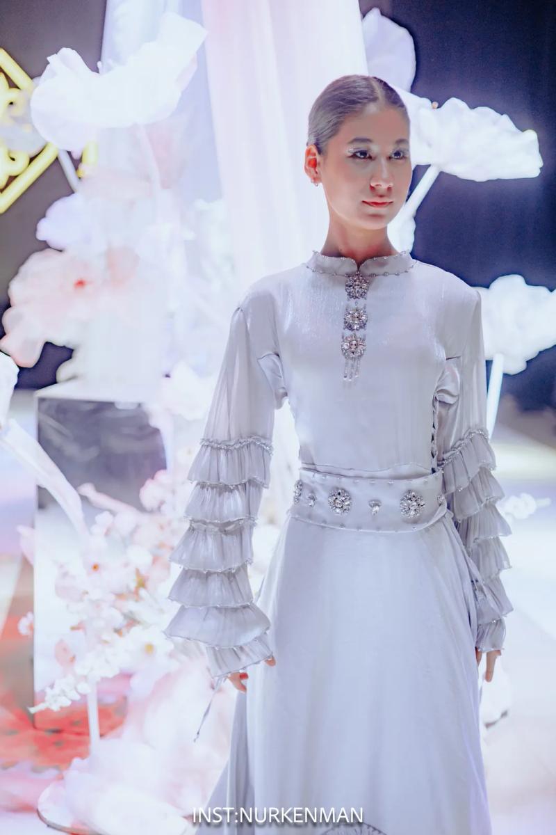Model in a pale dress with ruffled sleeves