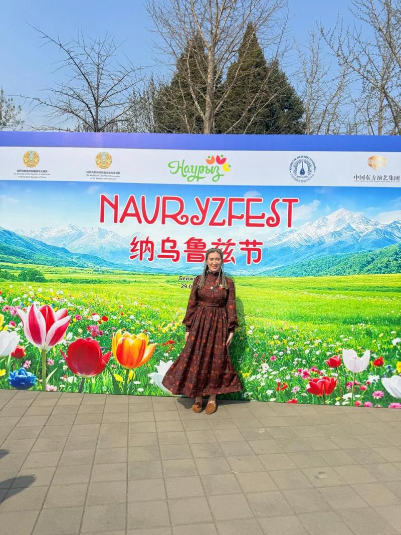 Banu Gaidar in front of the Nauryzfest banner