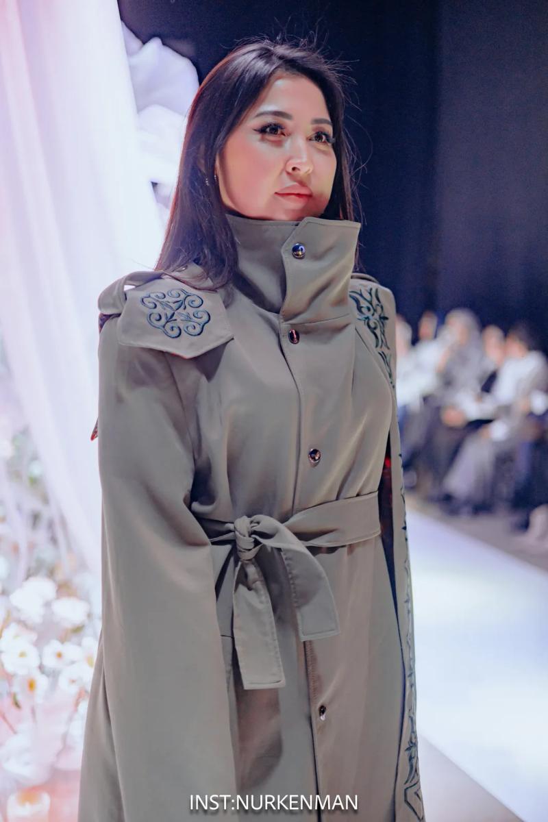 Model in an olive trench coat with ornament on the shoulders