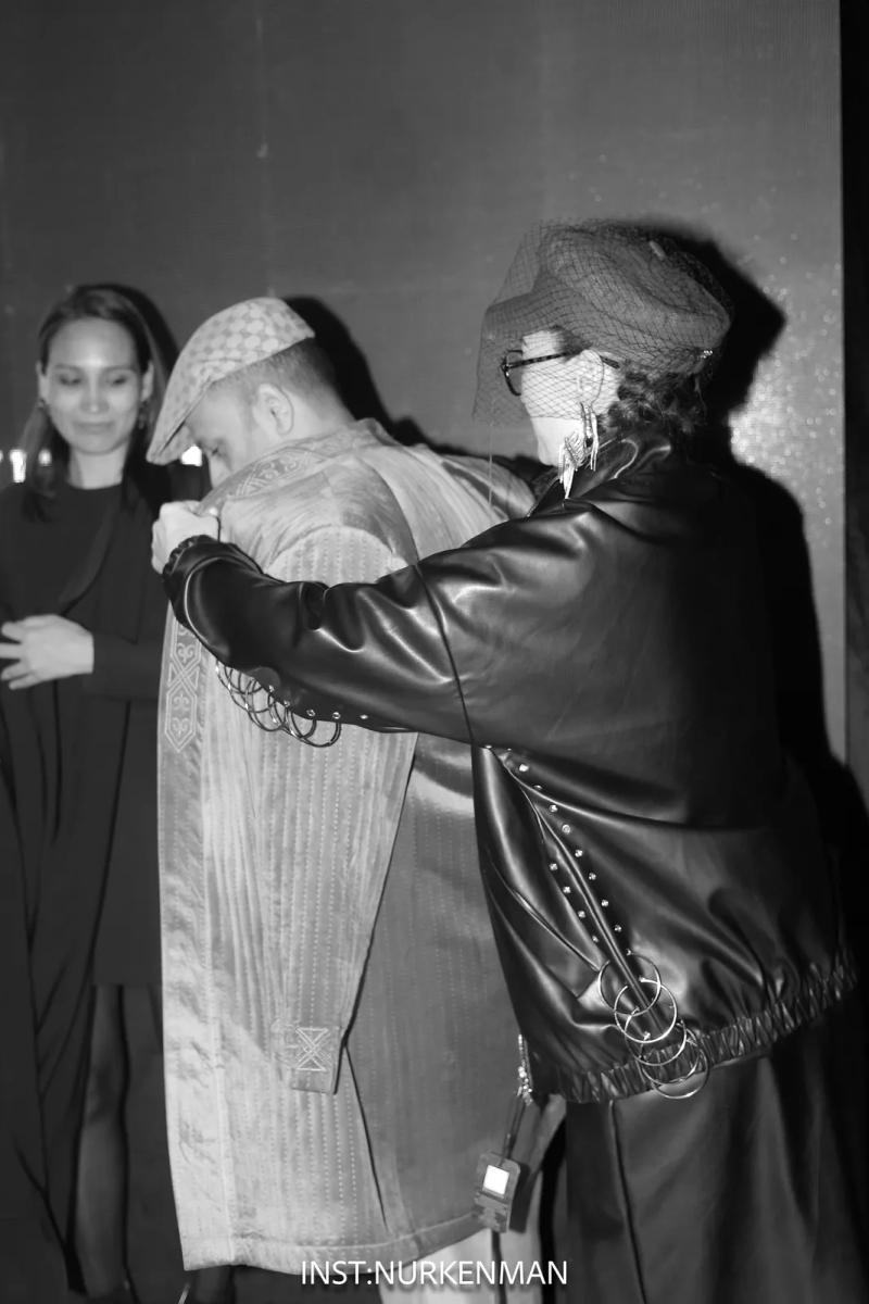 Backstage: a look is adjusted before the walk, black and white