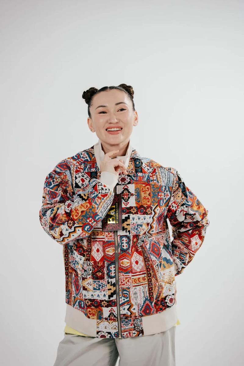 Banu Gaidar in a BAY bomber, smiling