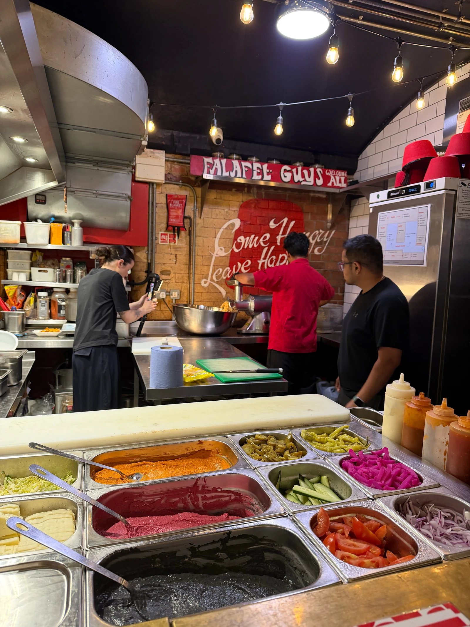 People at a Northern Market food counter with prepared ingredients in the foreground
