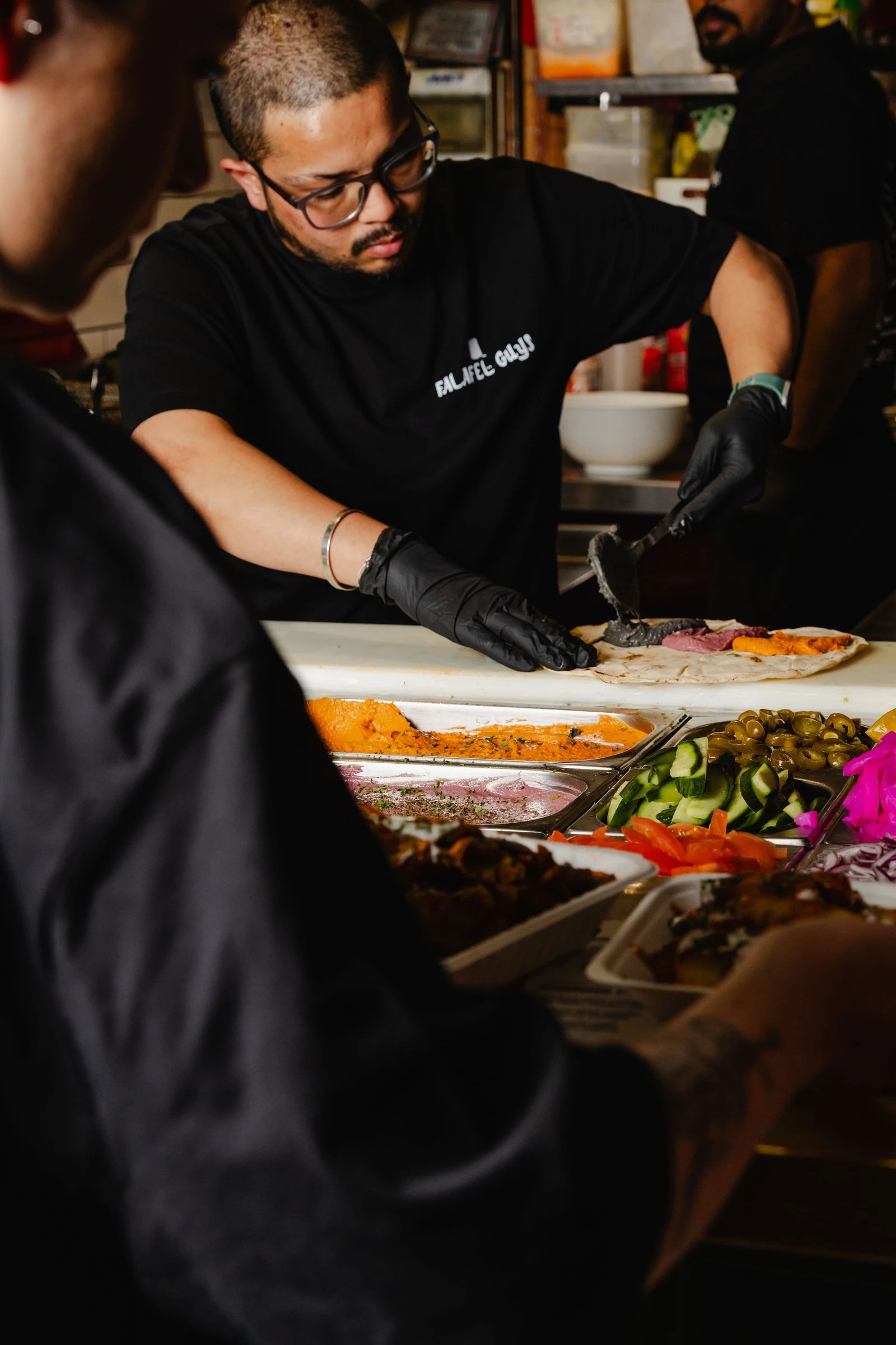 A person preparing a dish at a Northern Market food counter