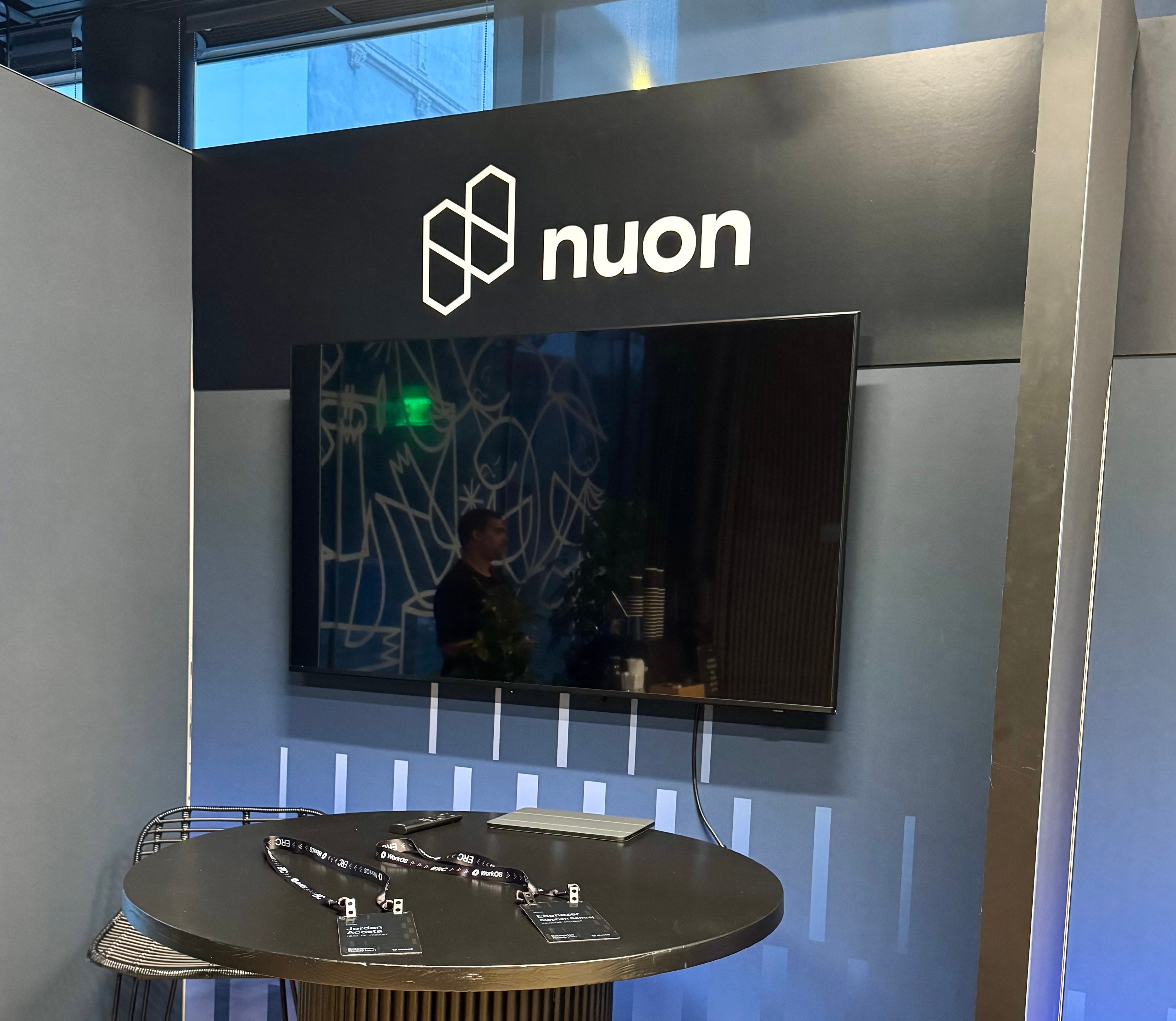 The Nuon booth with a black table and a tv for showing live demo's and pitch decks.