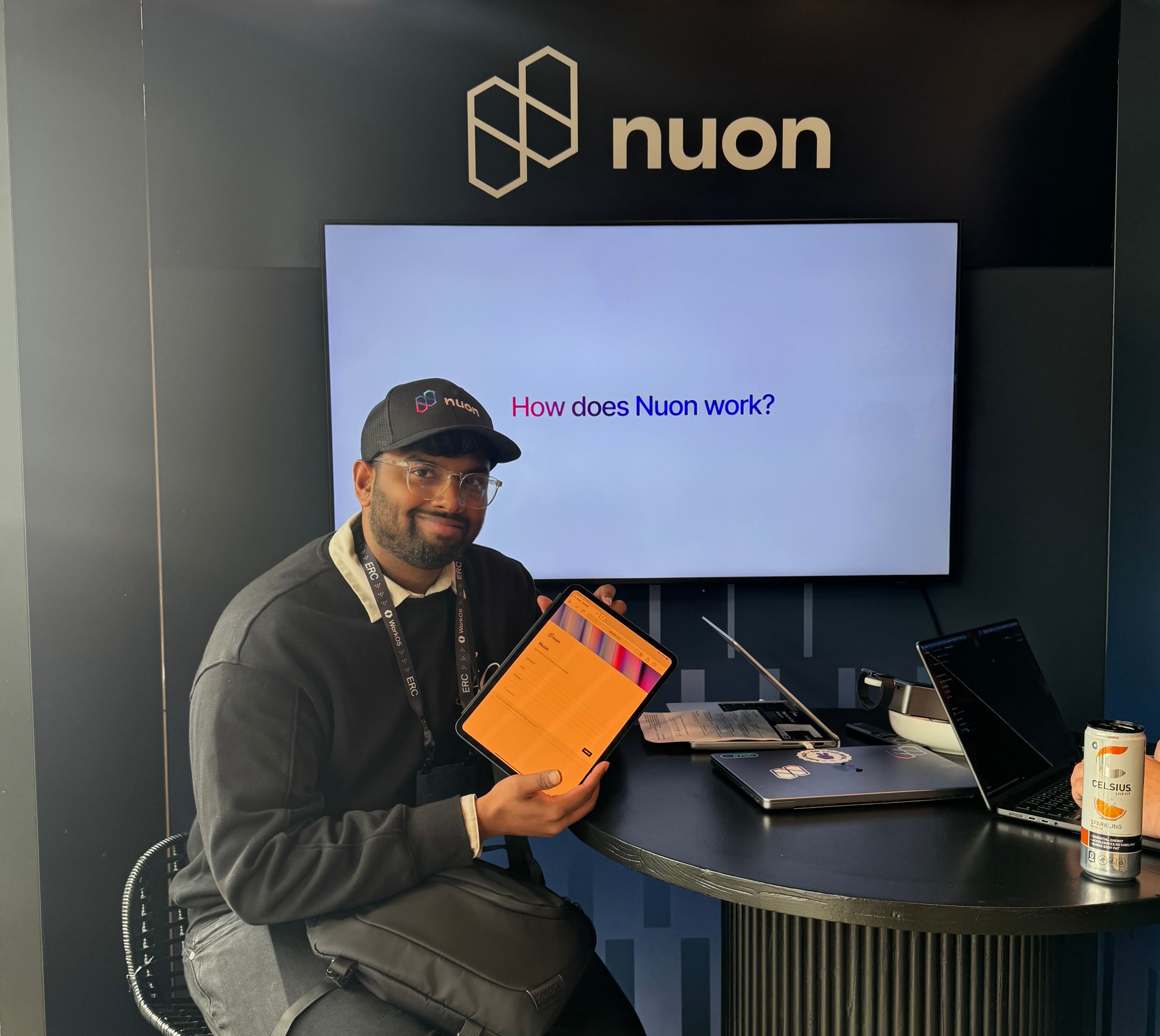 Nuon's designer holding down the fort and running the booth while holding up an ipad with our contact form on it