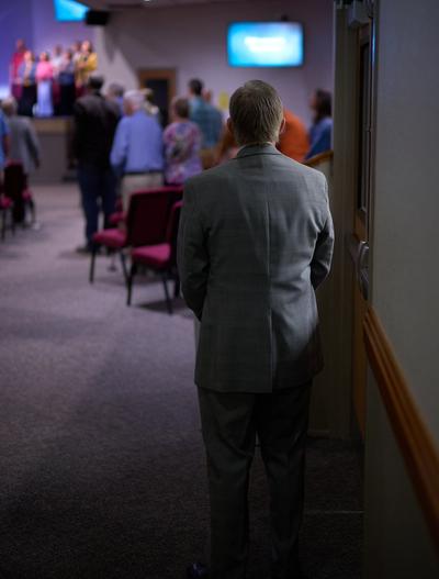 A man in a suit watches the service.
