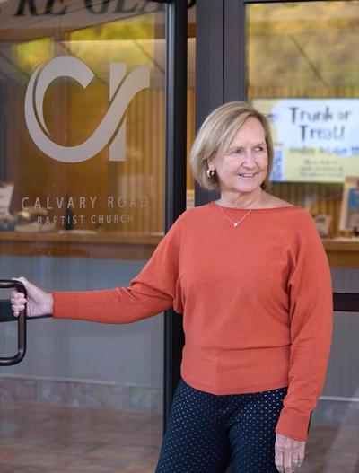 A lady holding open the door to the church.