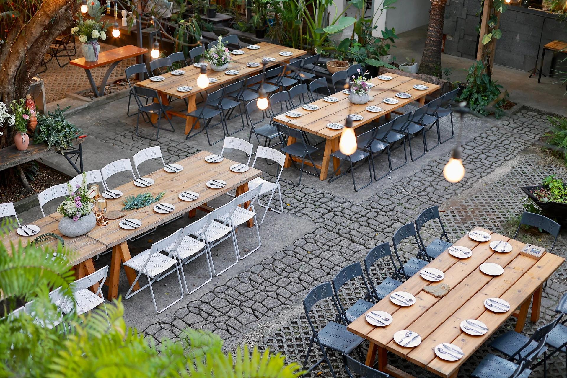 Scenic outdoor venue setup with rustic tables and floral decorations