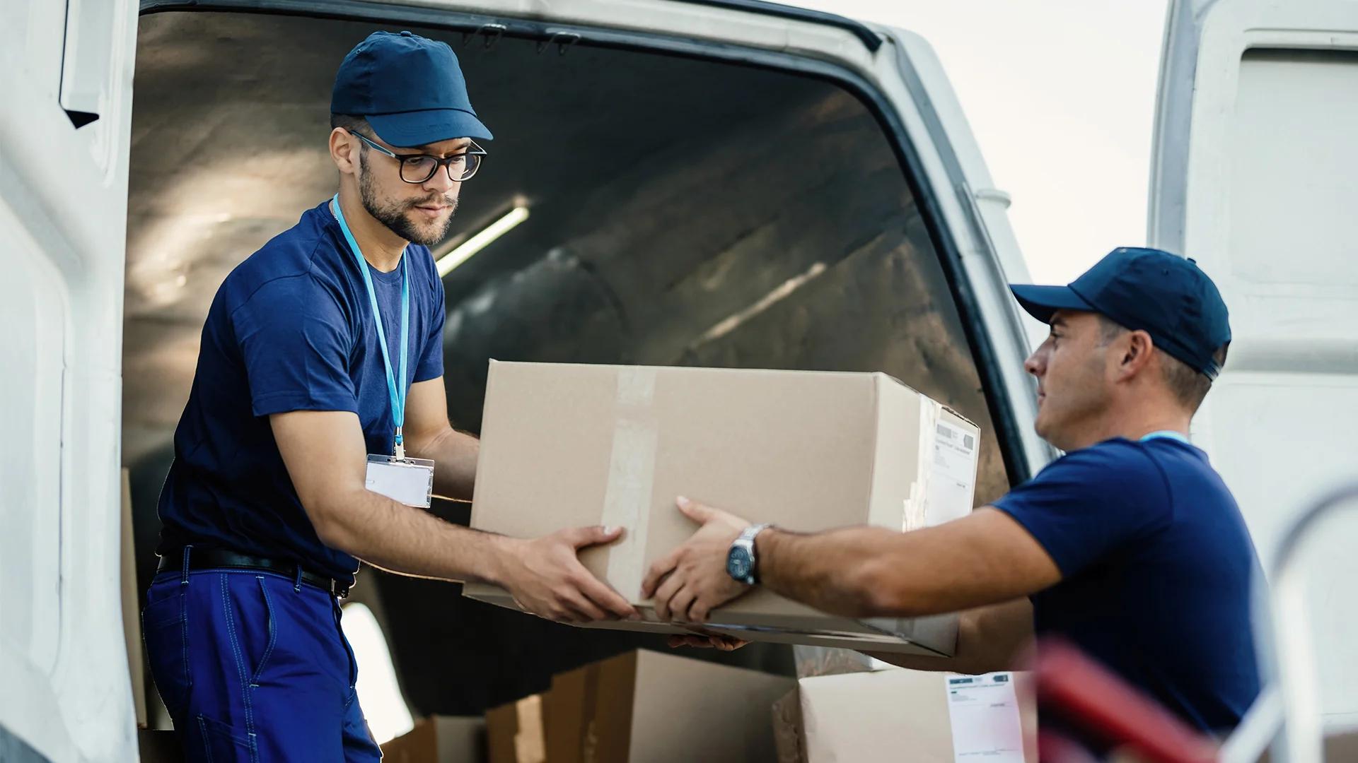 Delivery men loading carboard boxes