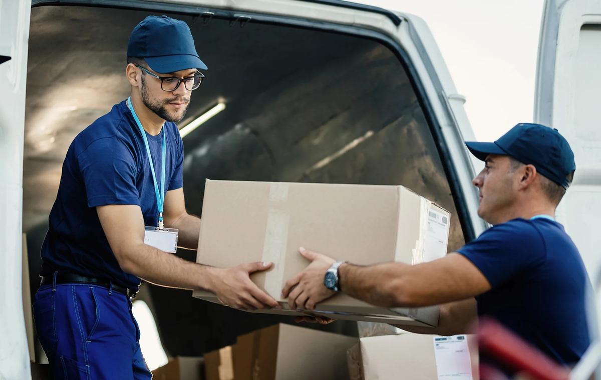 Delivery men loading carboard boxes