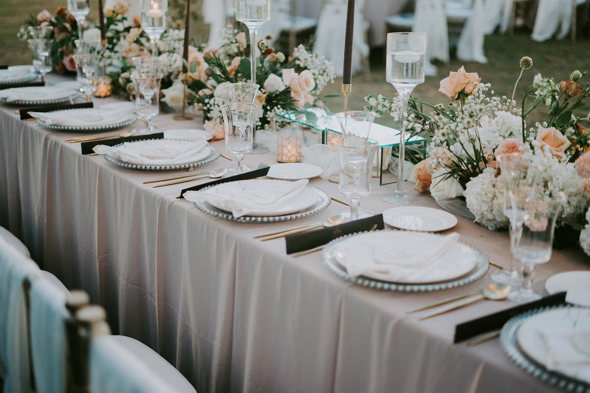 Beautifully decorated wedding reception table with floral arrangements and elegant tableware.