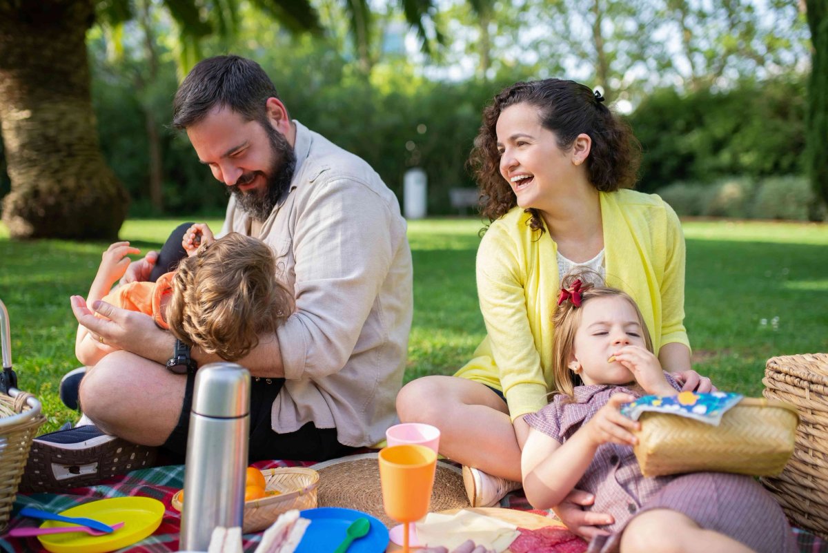 Famille pique-niquant dans un parc ensoleillé.