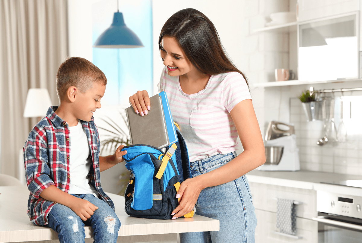Une mère et son fils prépare le sac d'école.
