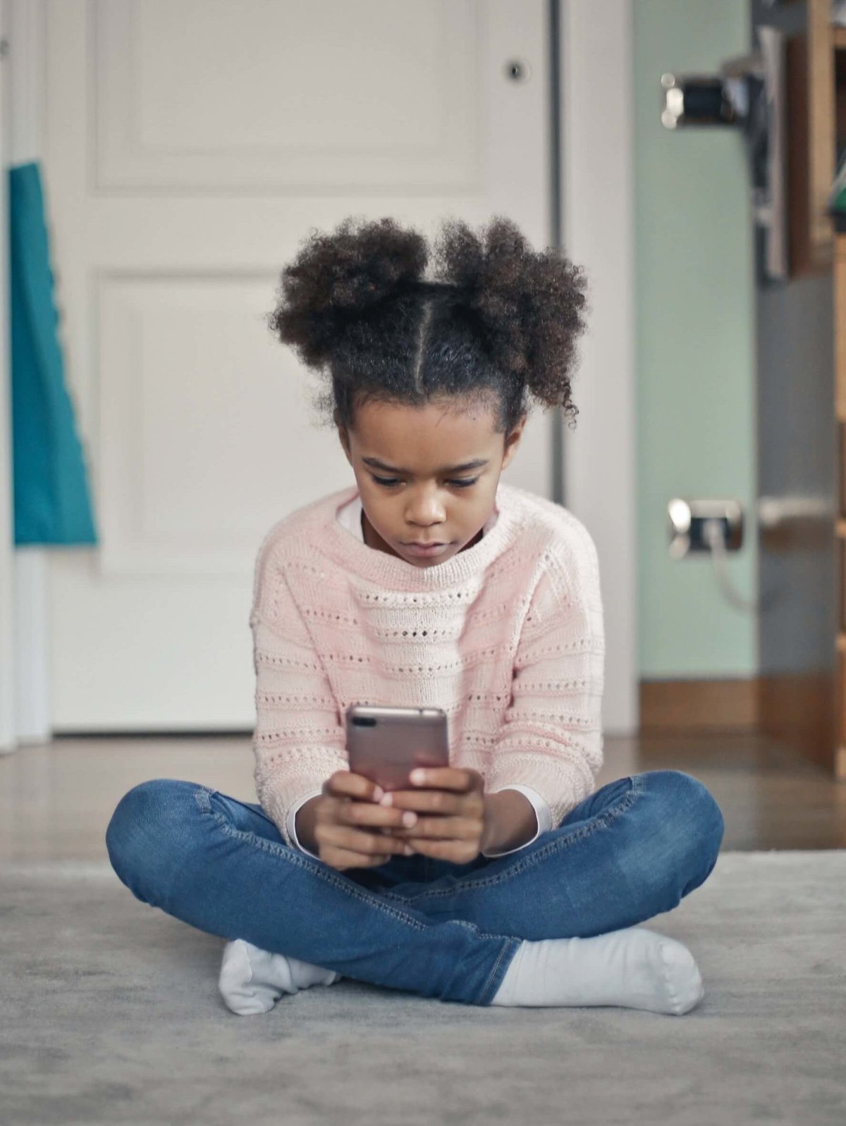 Enfant triste regarde son téléphone cellulaire.