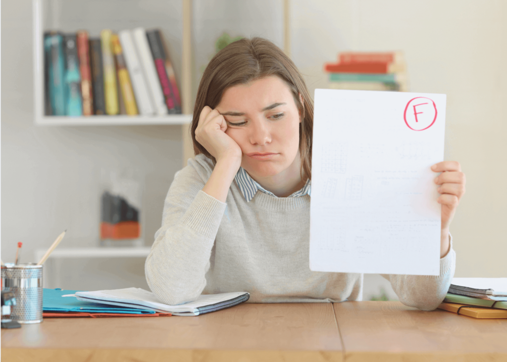 Adolescent appuyée sur le bureau montre son résultat d'examen (F) l'air decouragé. Elle a coulé son examen.