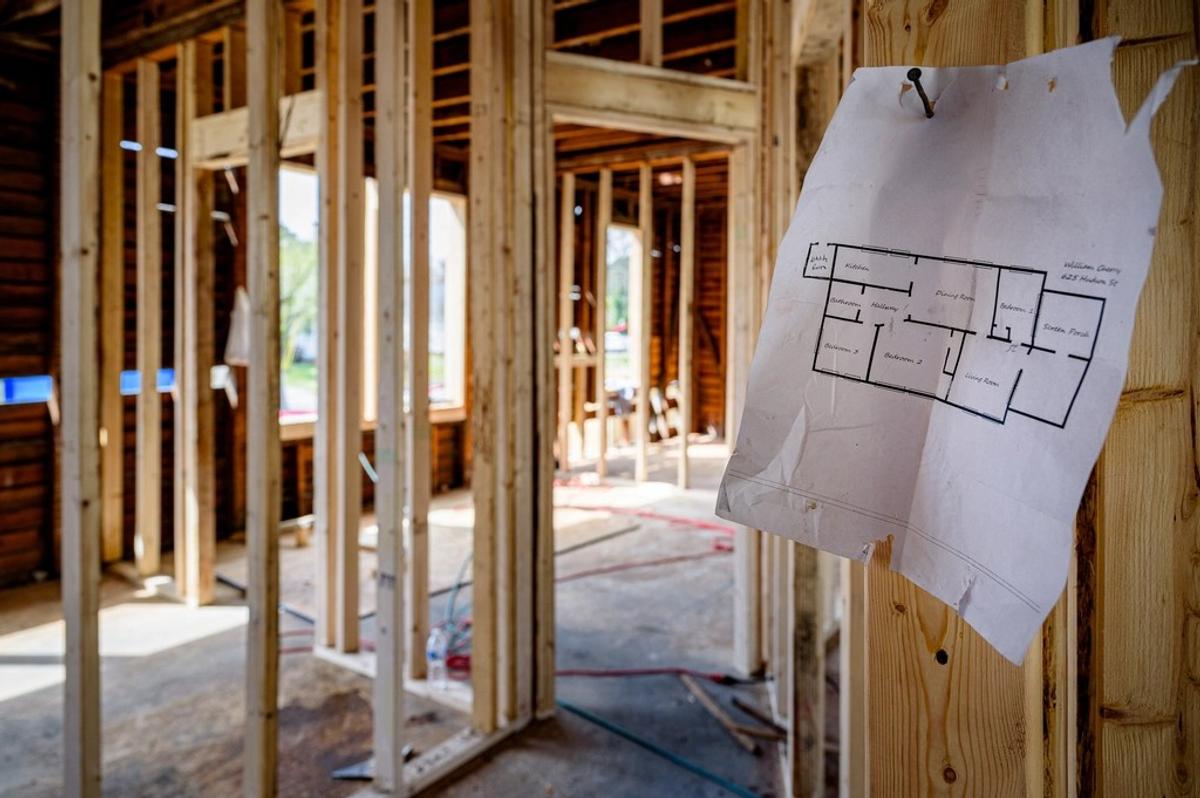Plano de distribución clavado en la estructura de madera de una casa en remodelación