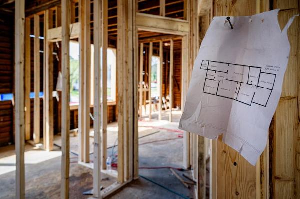 Plano de distribución clavado en la estructura de madera de una casa en remodelación