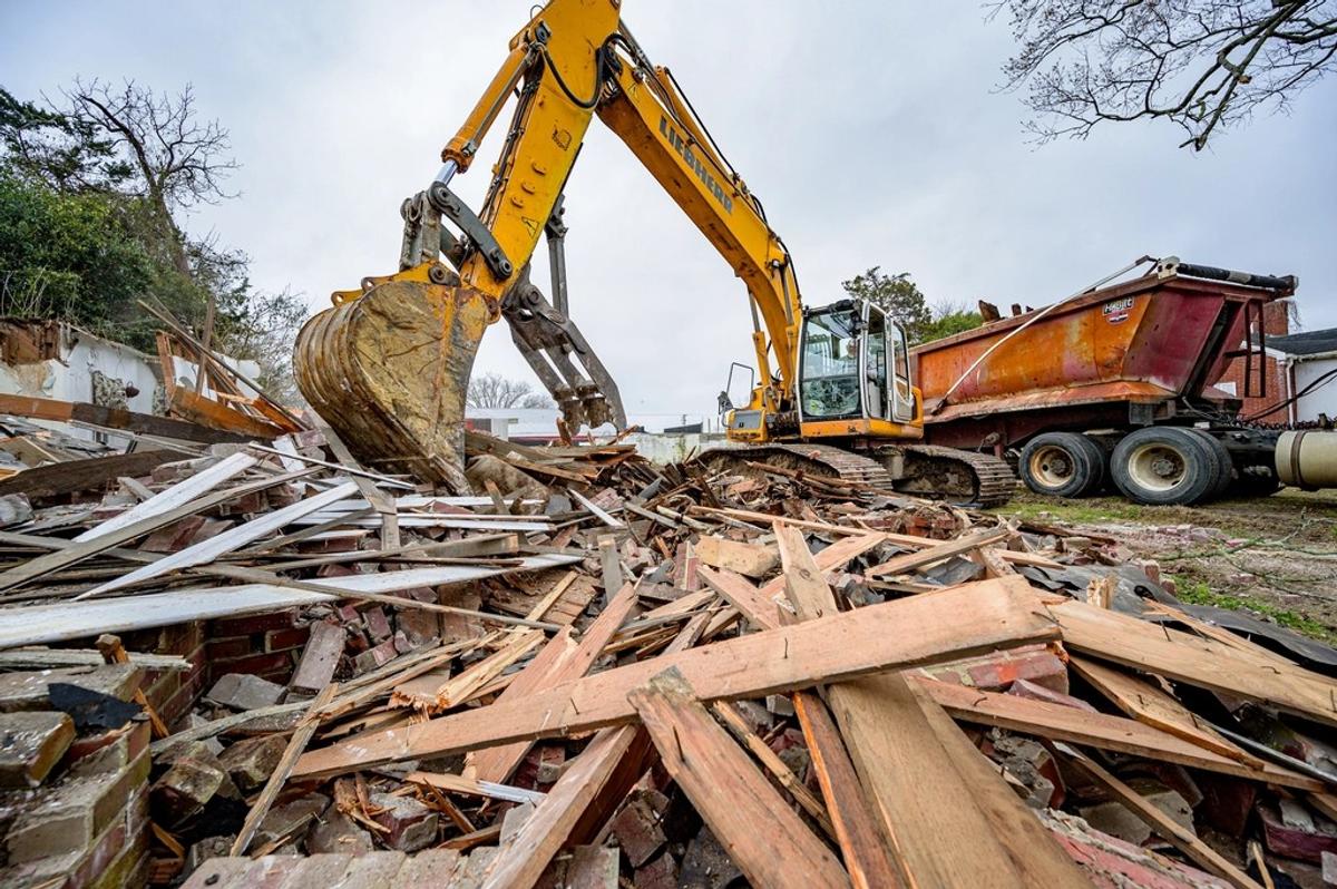 Excavadora demoliendo una casa antigua para construir de nuevo