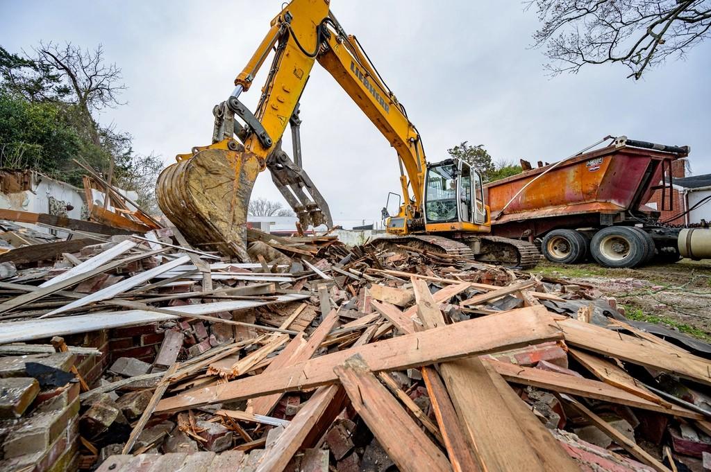 Excavadora demoliendo una casa antigua para construir de nuevo