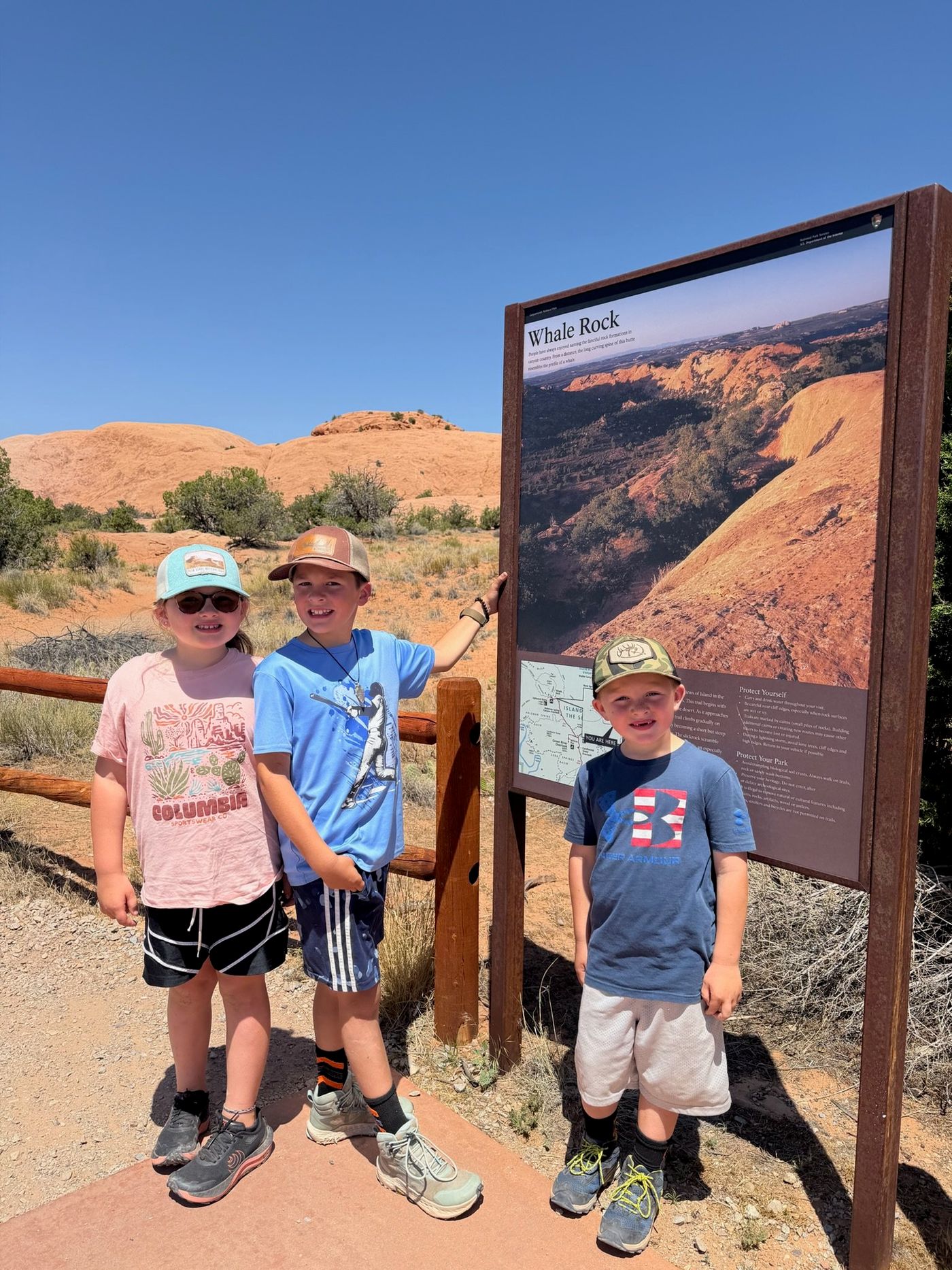 Three children beside the Whale Rock trail sign.