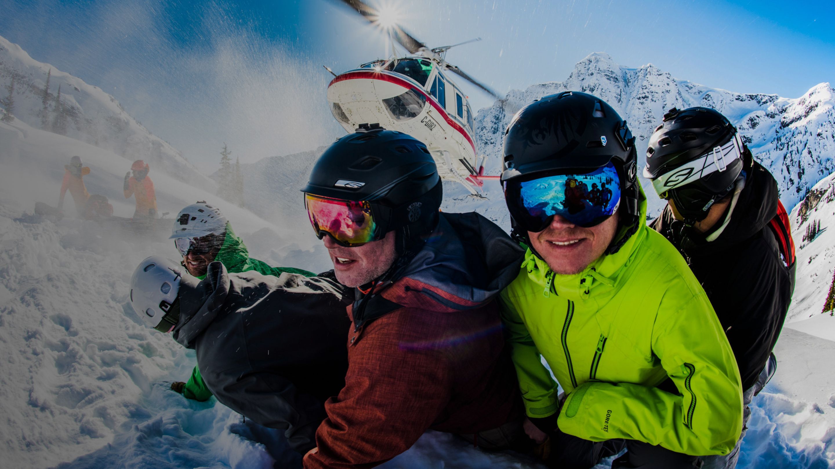 Group of skiers kneeling in front of a Heli