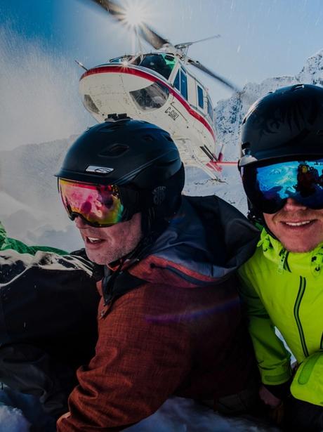 Group of skiers kneeling in front of a Heli