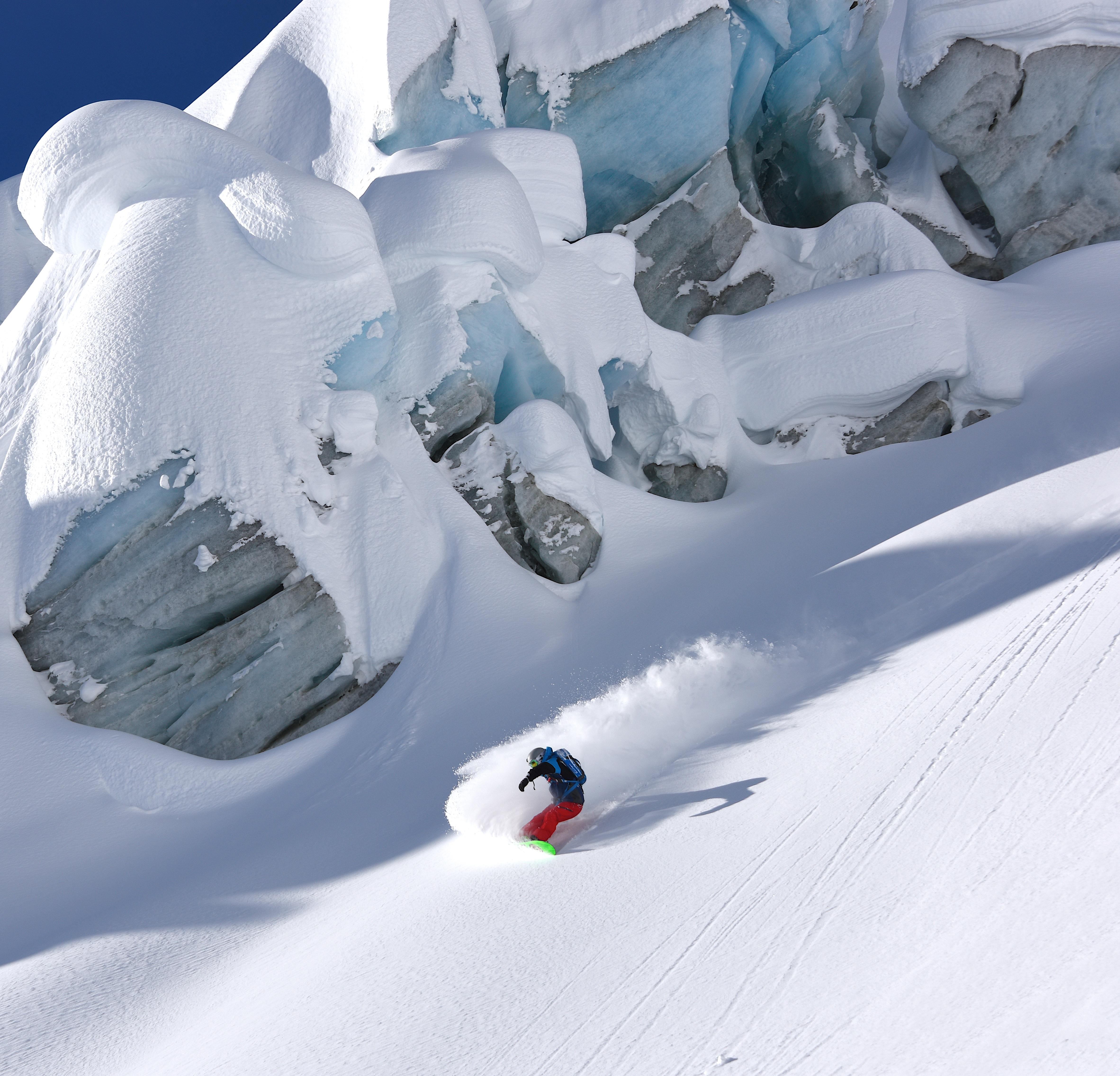 Snowboarder near large ice formations