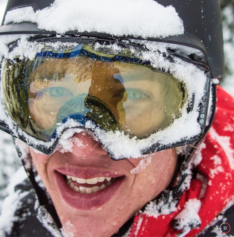 A man smiling with snow on his face