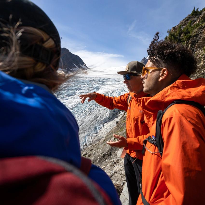 Guide talking to guests with a glacier in the background