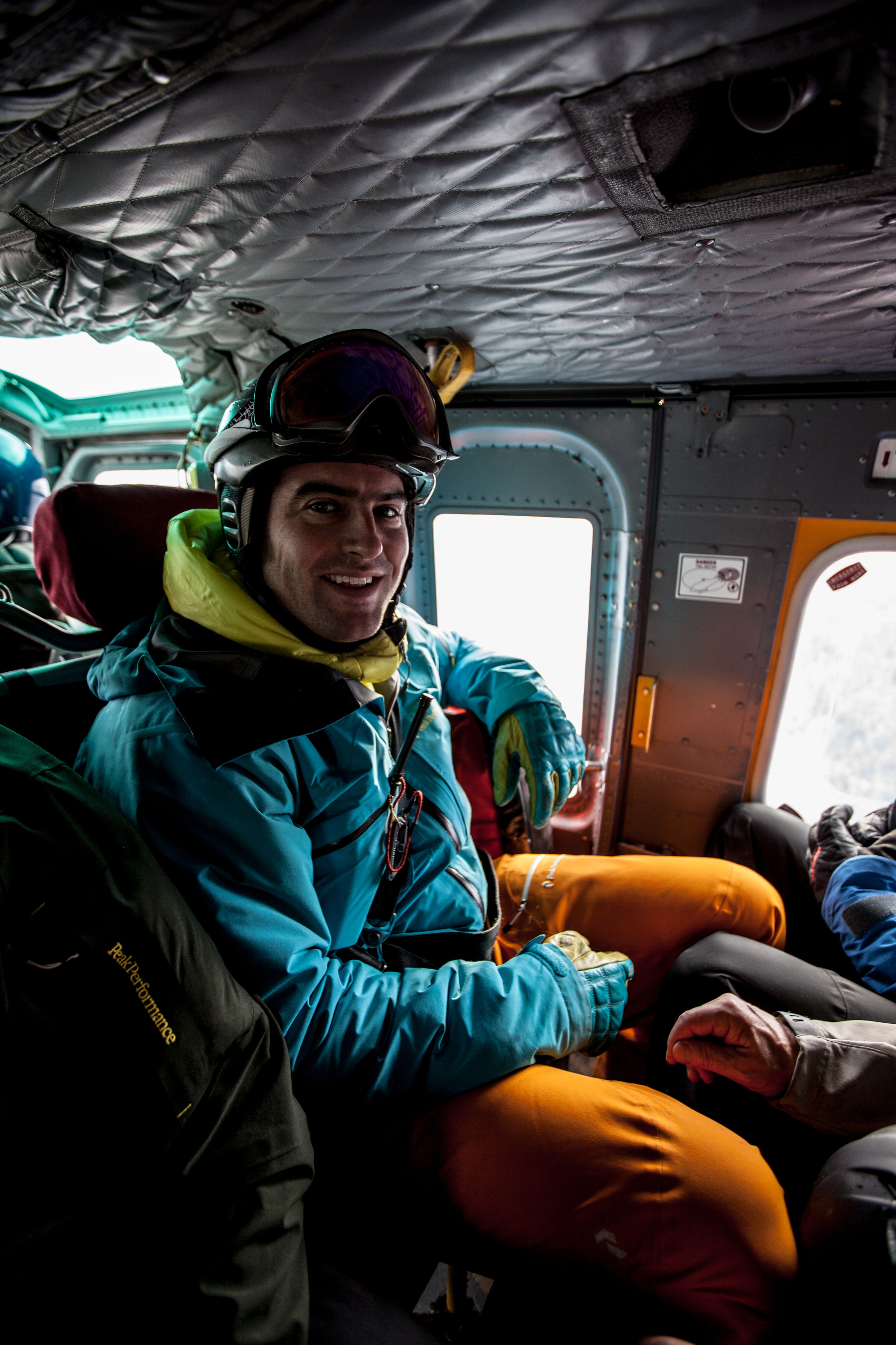 A skier seated in a helicopter