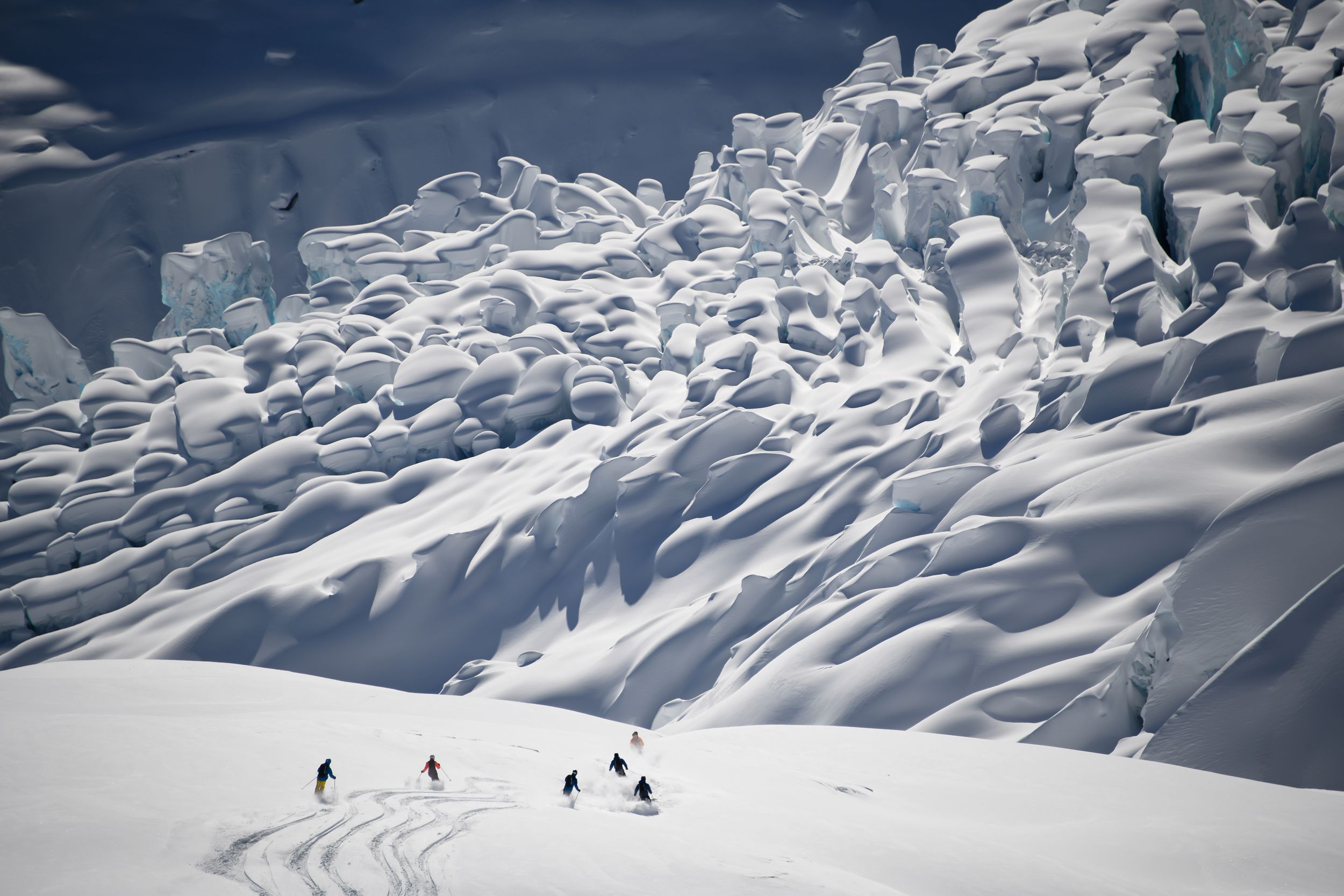 A group of skiers descending towards a glacier