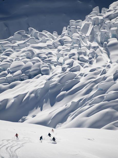 A group of skiers descending towards a glacier
