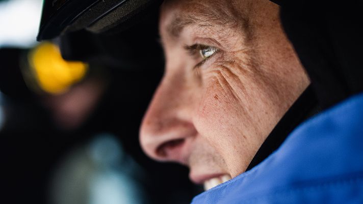 Portrait of a skier wearing a black helmet and a blue jacket.