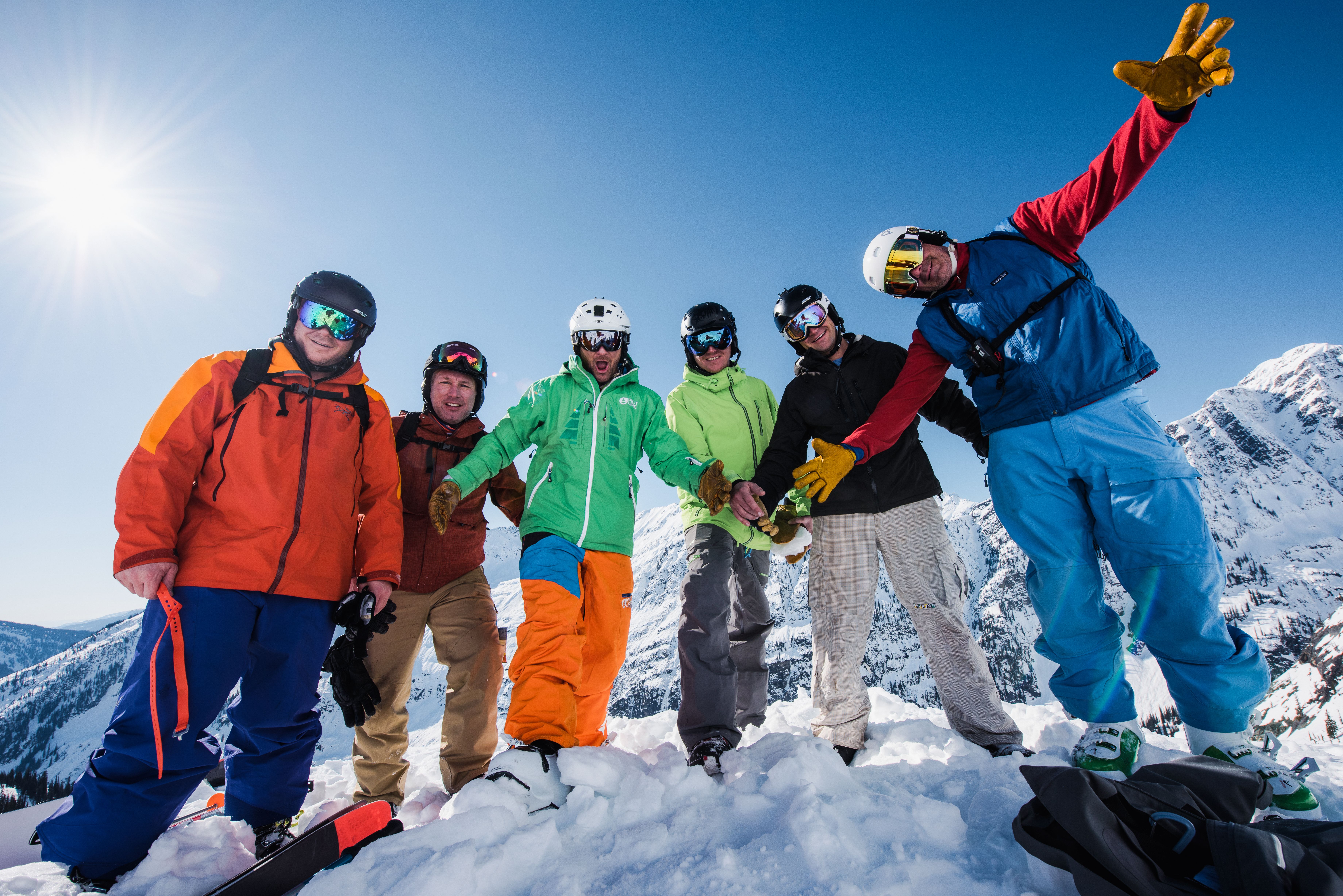 A helicopter flys over a group of skiiers 