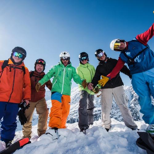 A helicopter flys over a group of skiiers