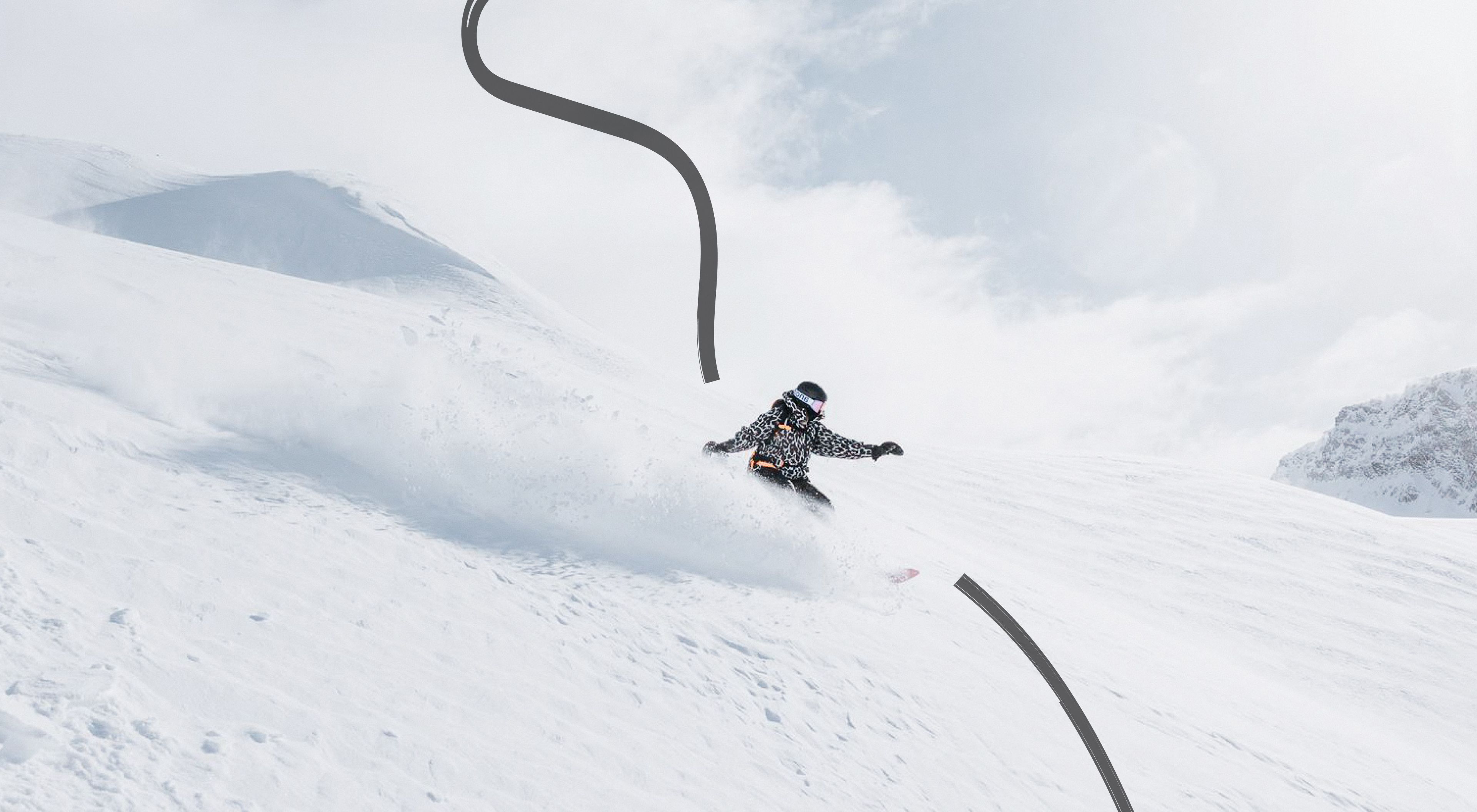 Snowy mountain scenery and a single snowboarder making a turn.