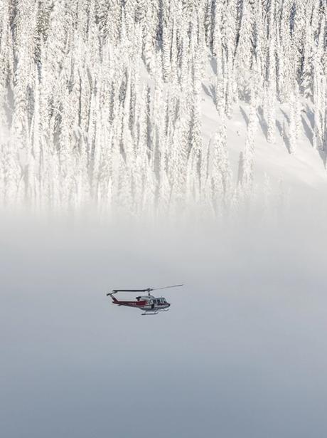 Helicopter in flight above a snowy mountain side