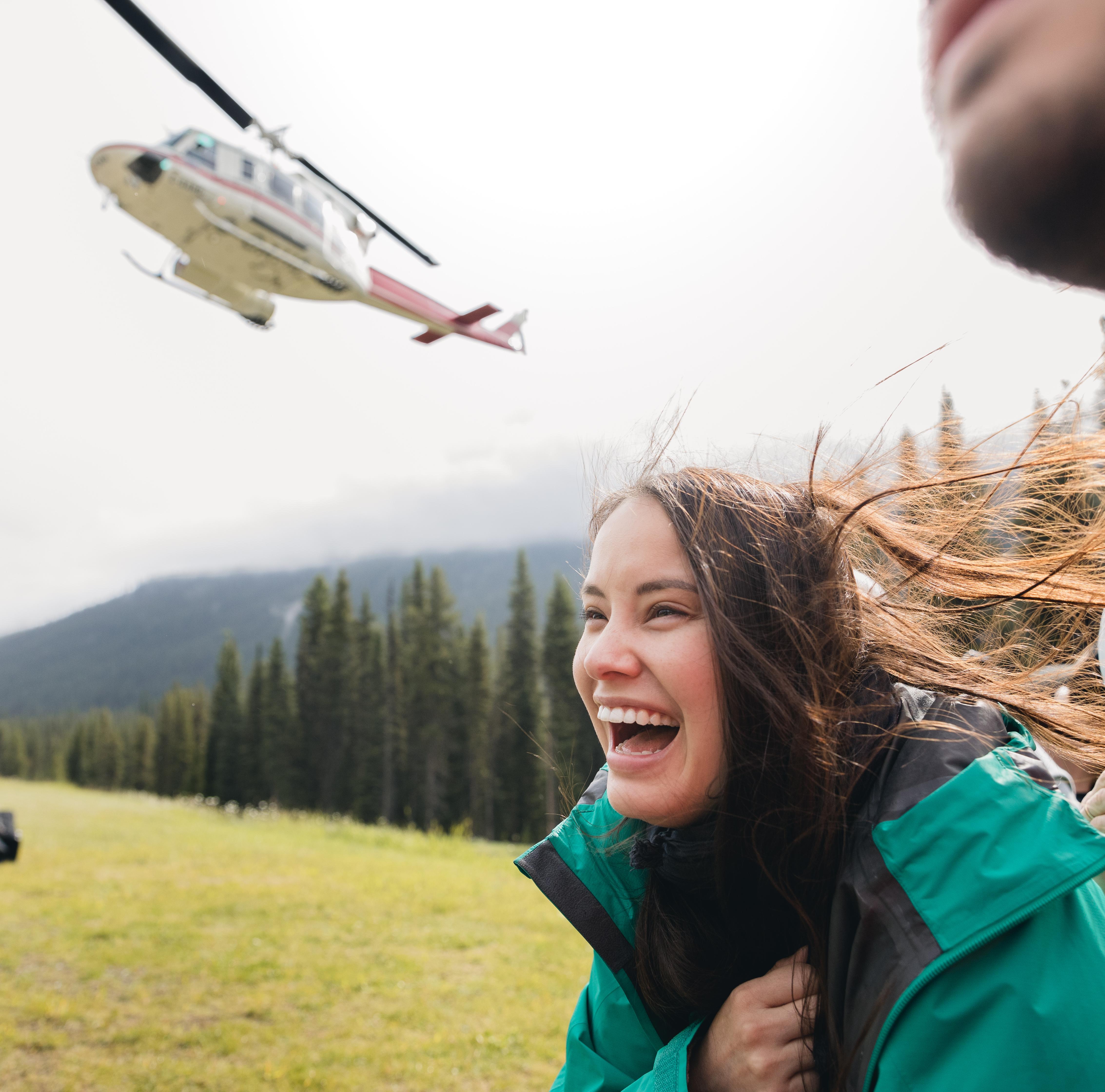 A smiling woman with a helicopter in the background
