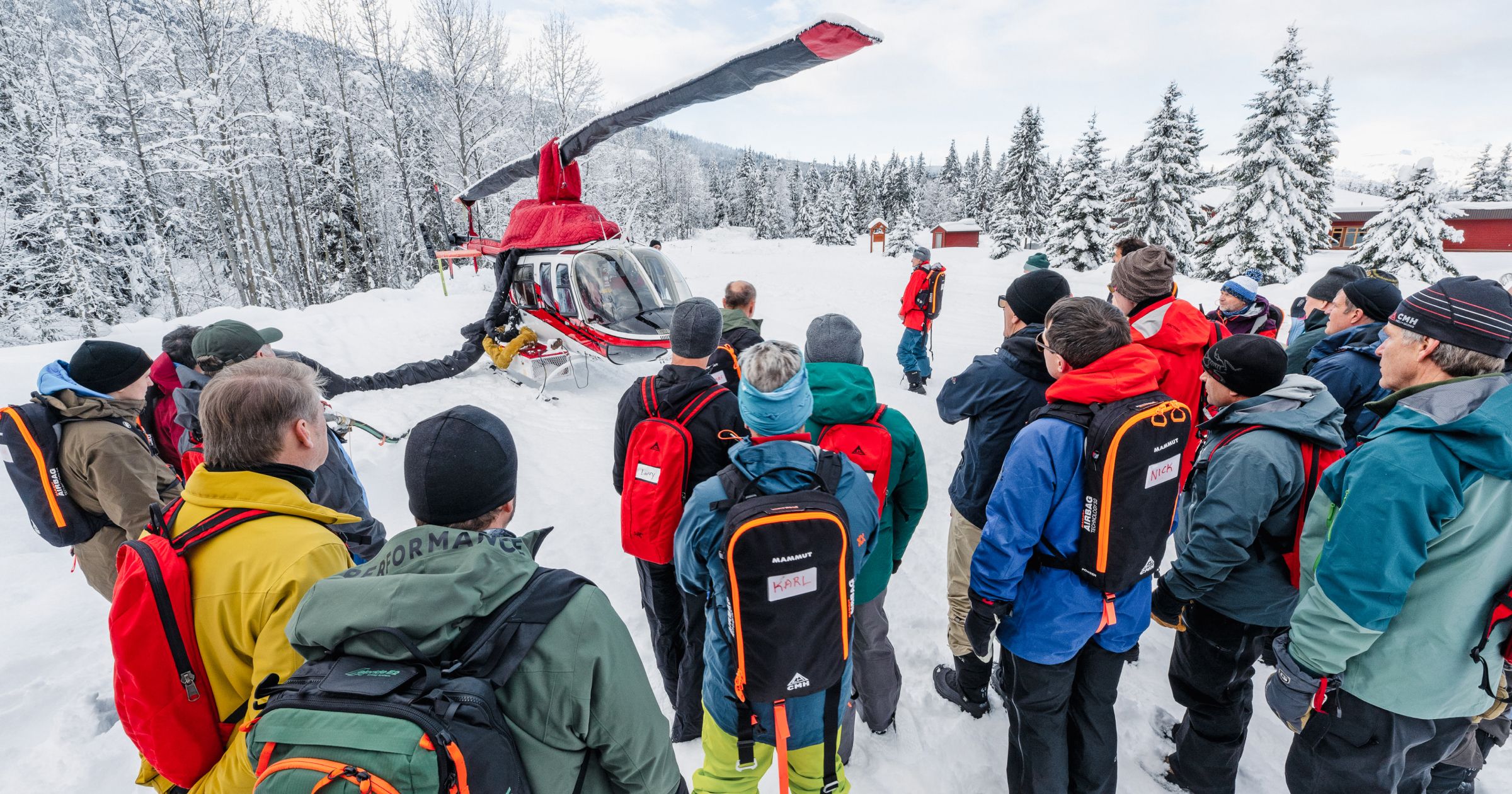 A group of people stand outside of a helicopter for a safety briefing