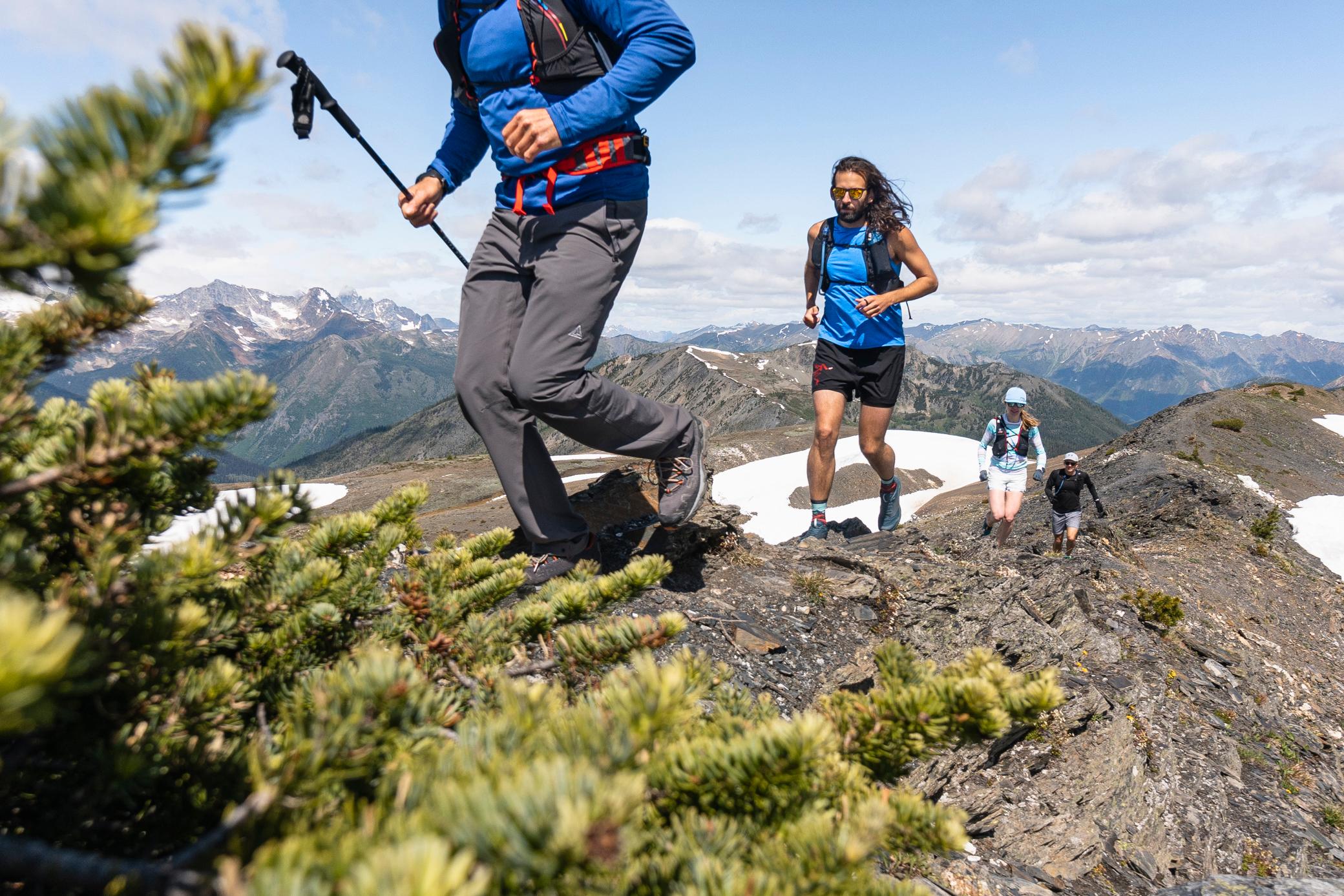 Group of people running on a mountain ridge