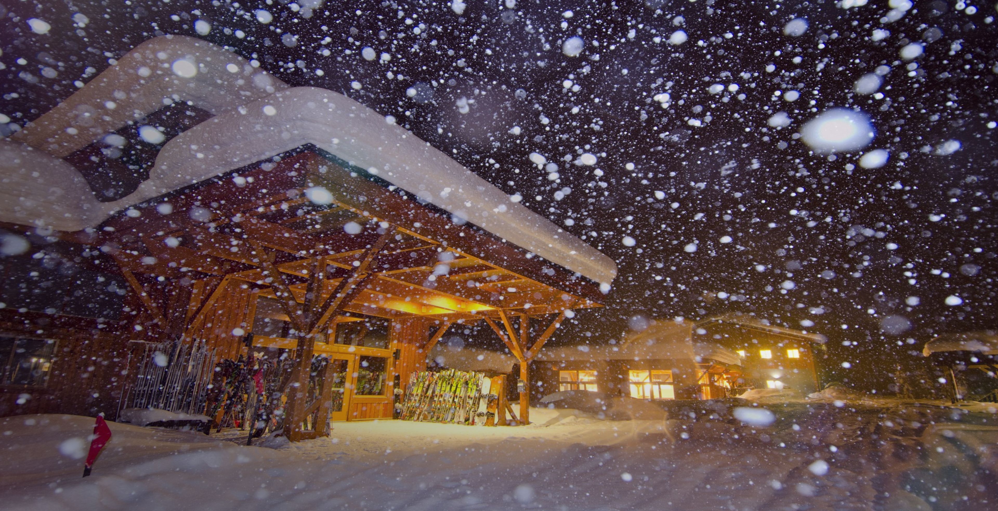 Big snow flakes fall outside of a CMH Lodge