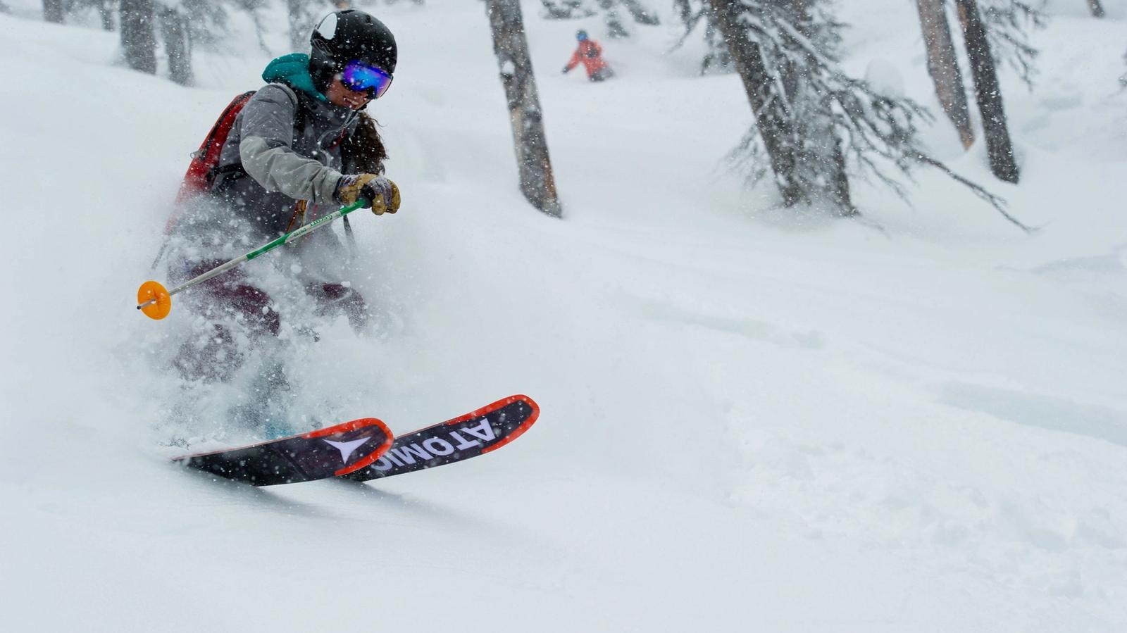 Woman skiing through trees
