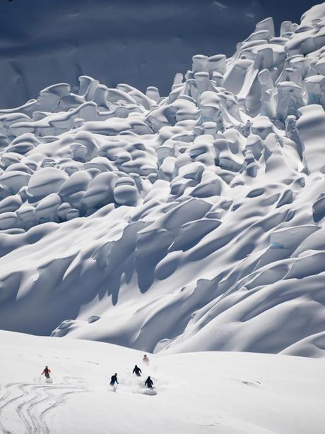 A group of skiers descending towards a glacier