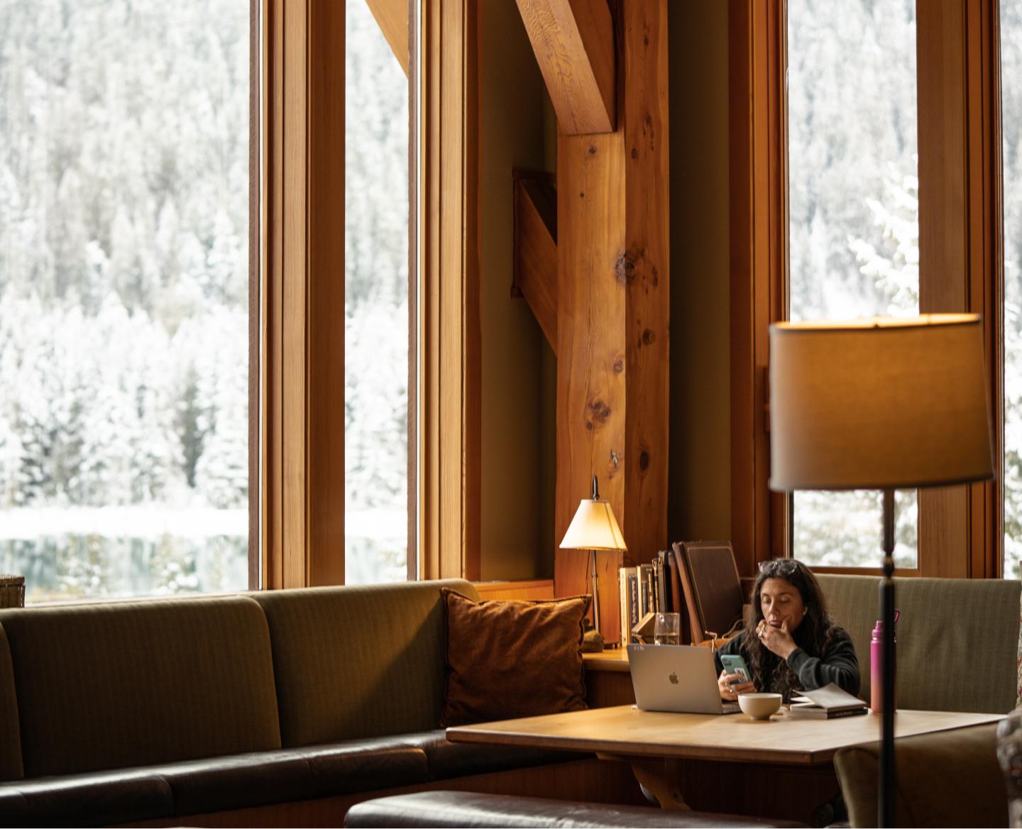 A person sits at their computer in a cozy, warm CMH lodge