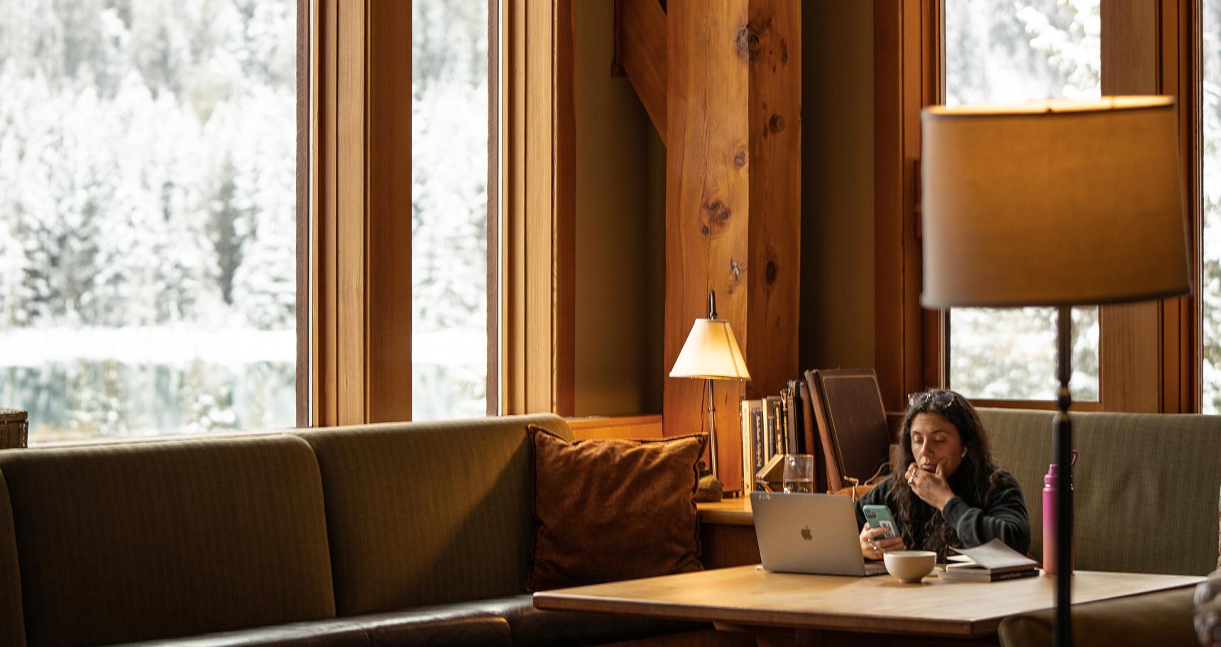 A person sits at their computer in a cozy, warm CMH lodge