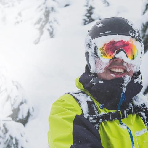Skier smiling in a snowy forest